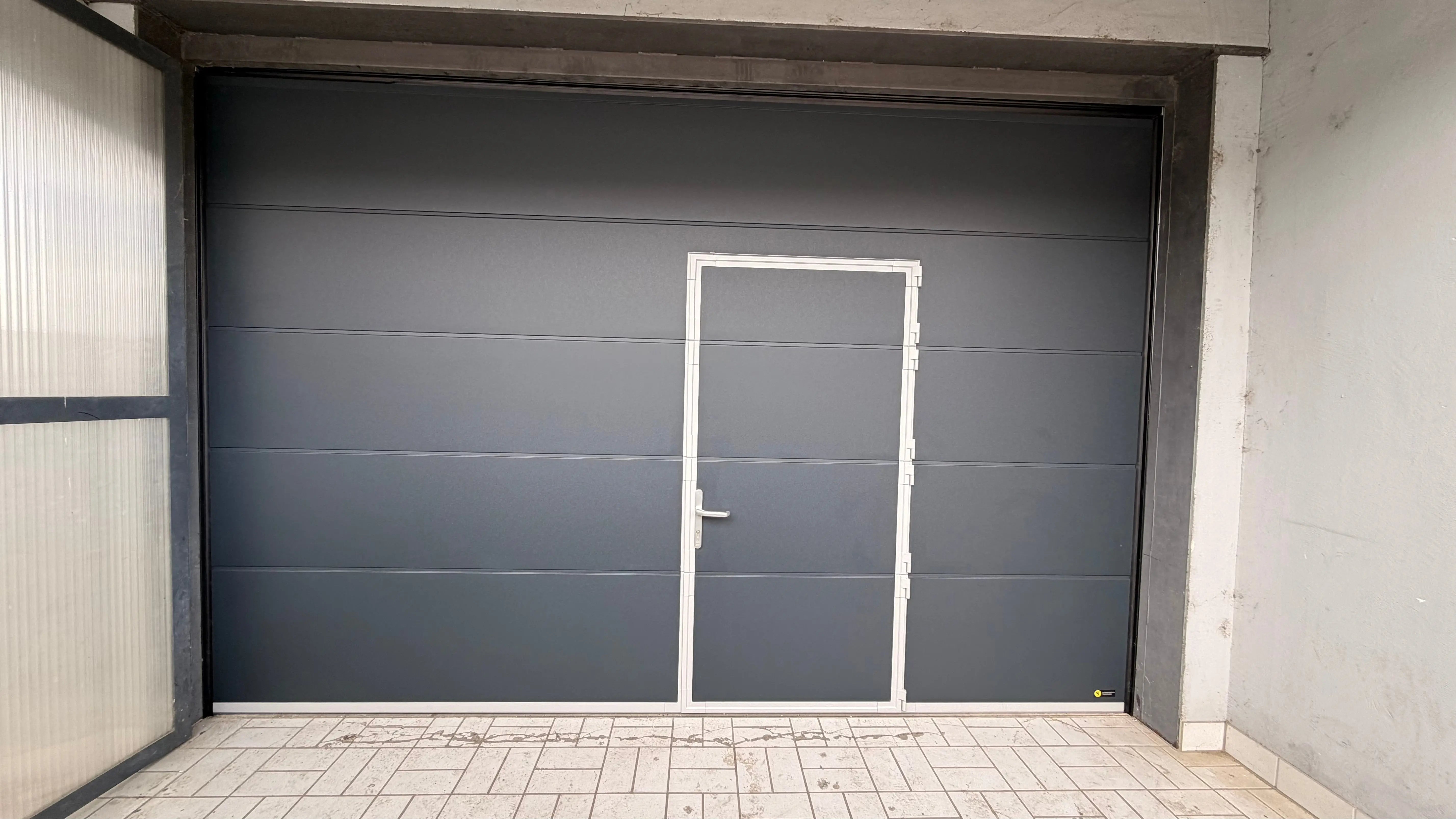 moderne Garagen-porte sectionnelle ersetzt ein altes porte basculante, avec lisse surface, motorisation de porte de garage, émetteur portatif et joint d’étanchéité als hochwertige modernisation von Tormeister24.